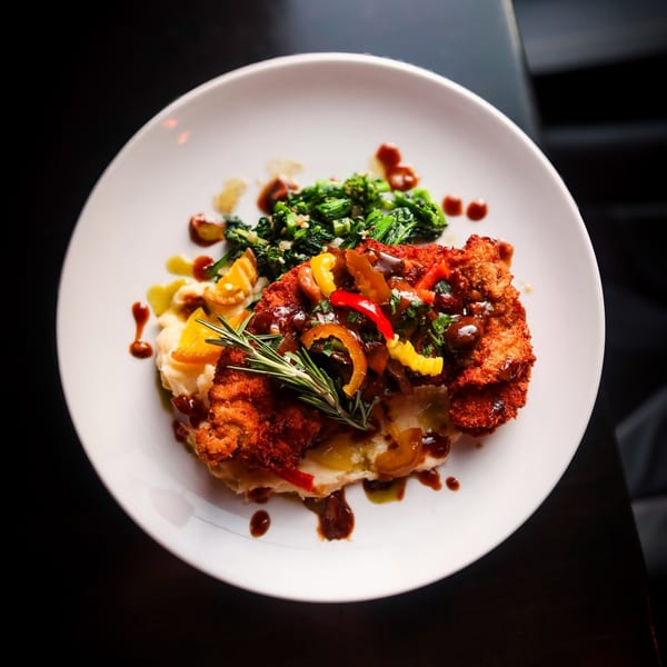 Nunzi's Italian chicken cutlet with mashed potatoes, sauteed spinach, peppers, and rosemary.