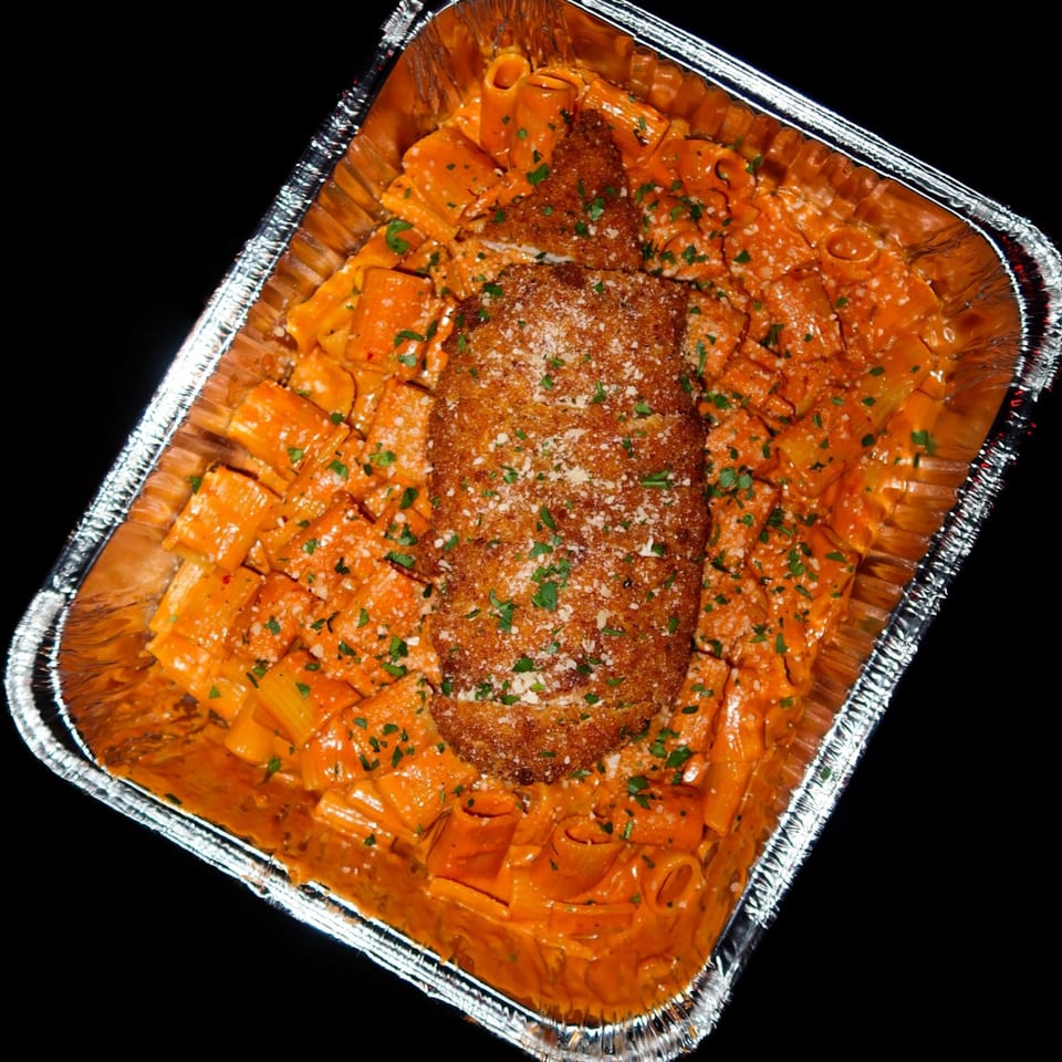 Nunzi's rigatoni with vodka sauce and a breaded chicken cutlet in a foil pan.